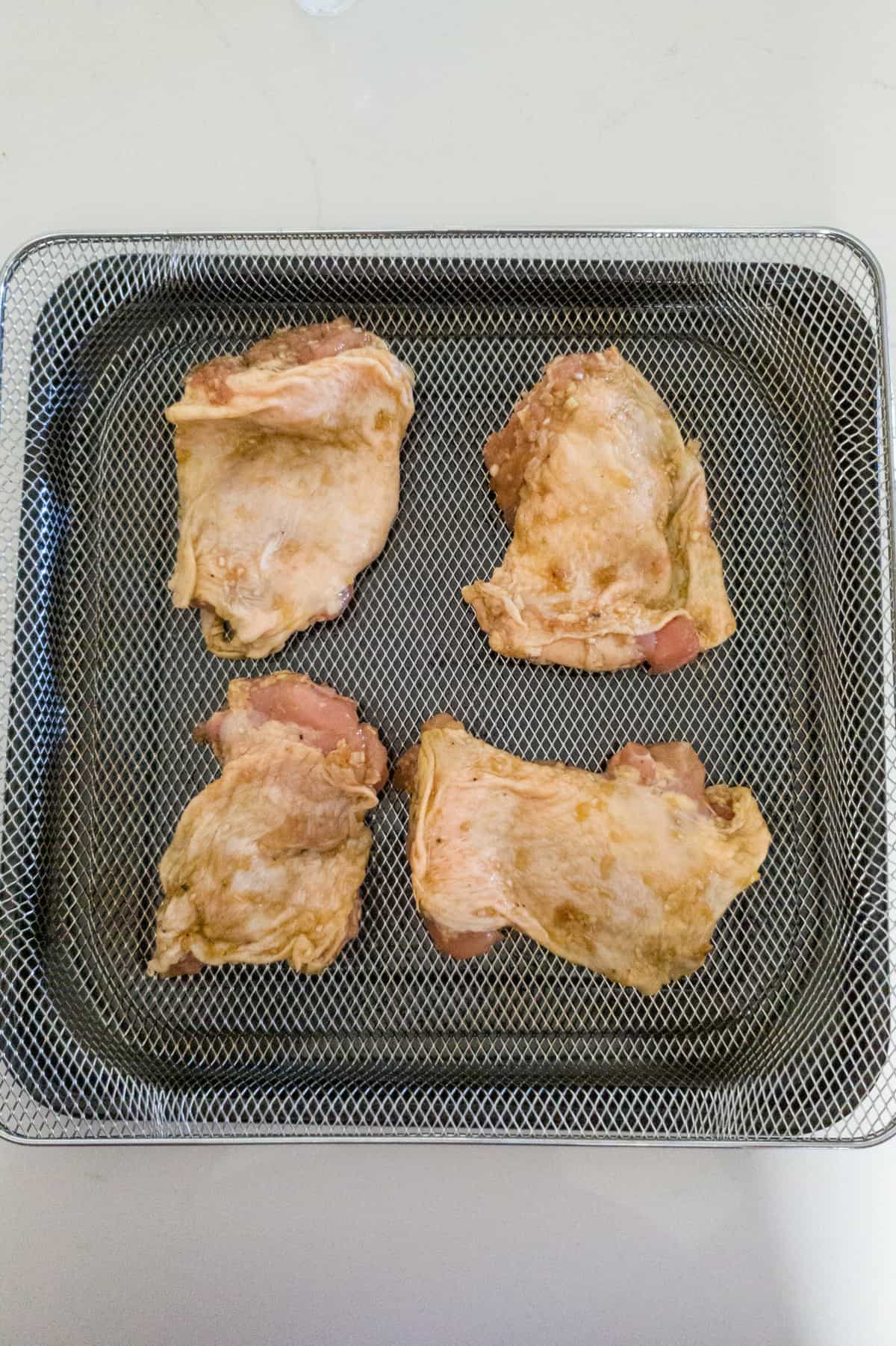 Raw chicken on air fryer tray